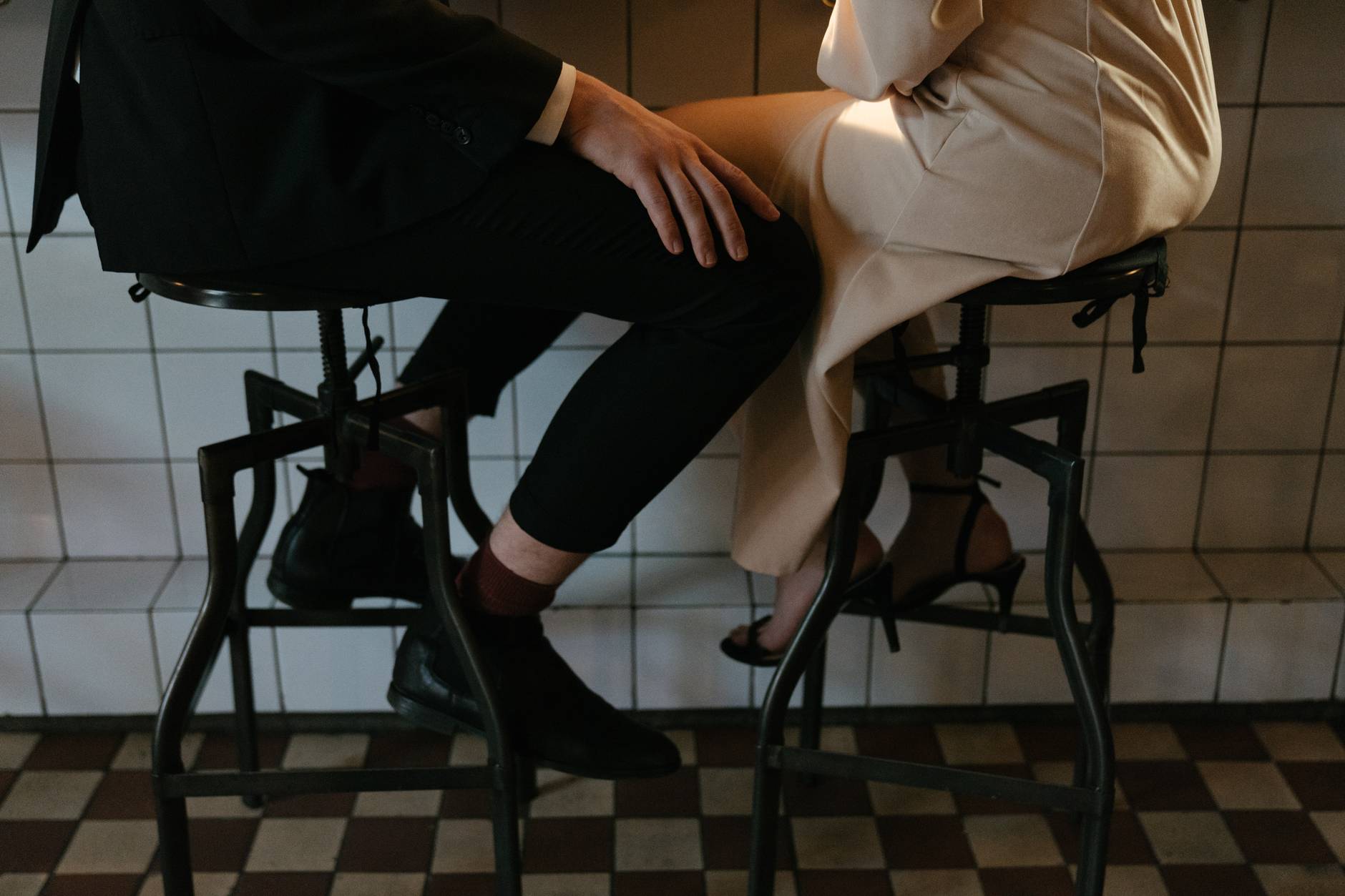 person in black pants sitting on white chair